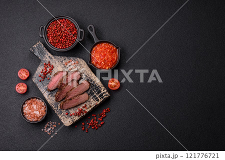 Juicy beef steak baked on the grill with salt, spices and herbs Juicy beef steak baked on the grill with salt, spices and herbs 121776721