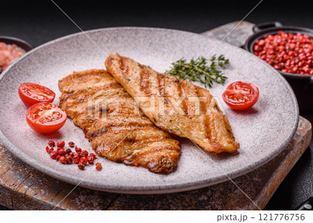 Juicy chicken fillet baked on the grill with salt, spices and herbs 121776756
