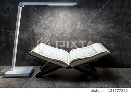 Desk lamp with Quran on Quran matt on a black background 121777236
