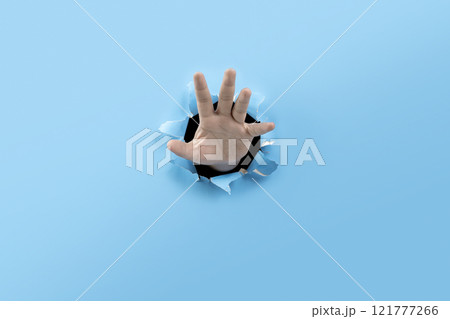 Human hand showing his palm from ripped paper Human hand showing his palm from ripped paper 121777266