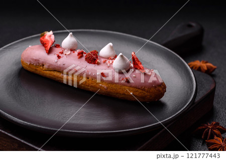 Sweet eclair or profiterole with strawberry custard 121777443