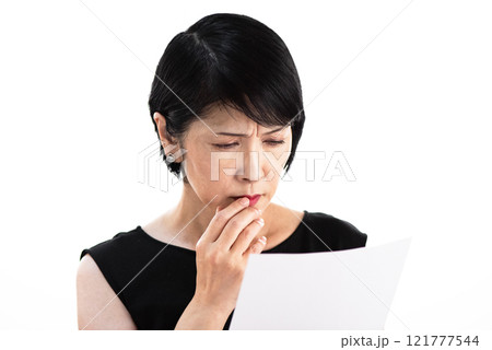 書類を見ながら苦悩するミドル女性 書類を見ながら苦悩するミドル女性 121777544
