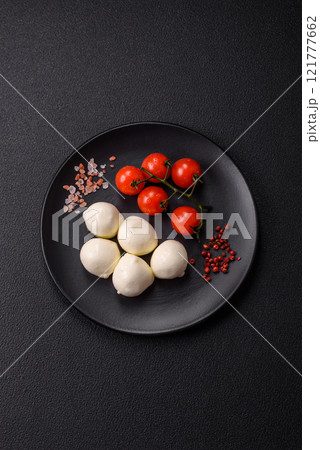 Delicious fresh mozzarella cheese with tomatoes, salt and spices Delicious fresh mozzarella cheese with tomatoes, salt and spices 121777662