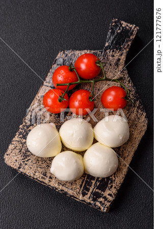 Delicious fresh mozzarella cheese with tomatoes, salt and spices Delicious fresh mozzarella cheese with tomatoes, salt and spices 121777676