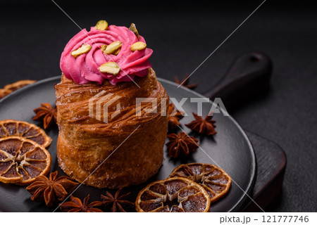 Sweet craffin or panettone garnished with raspberry and pistachio flavored cream Sweet craffin or panettone garnished with raspberry and pistachio flavored cream 121777746