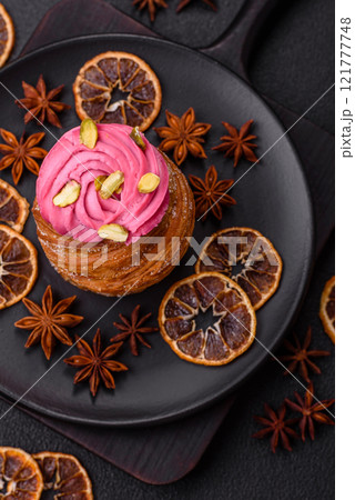 Sweet craffin or panettone garnished with raspberry and pistachio flavored cream Sweet craffin or panettone garnished with raspberry and pistachio flavored cream 121777748