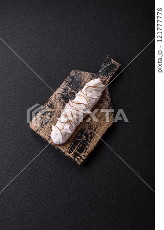 Sweet eclair with custard decorated with coconut slices 121777778