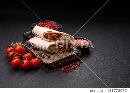 Roll with pita, meat, tomatoes, cheese, sauce, salt and spices Roll with pita, meat, tomatoes, cheese, sauce, salt and spices 121778077