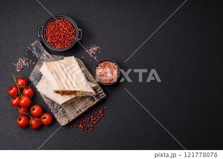 Roll with pita, meat, tomatoes, cheese, sauce, salt and spices 121778078