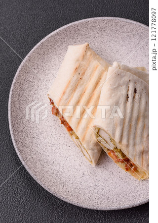 Roll with pita, meat, tomatoes, cheese, sauce, salt and spices Roll with pita, meat, tomatoes, cheese, sauce, salt and spices 121778097