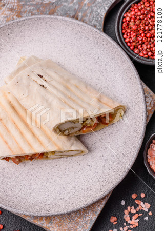 Roll with pita, meat, tomatoes, cheese, sauce, salt and spices Roll with pita, meat, tomatoes, cheese, sauce, salt and spices 121778100