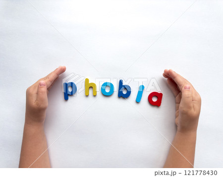 Colorful letters forming the word phobia with hands on a white background 121778430