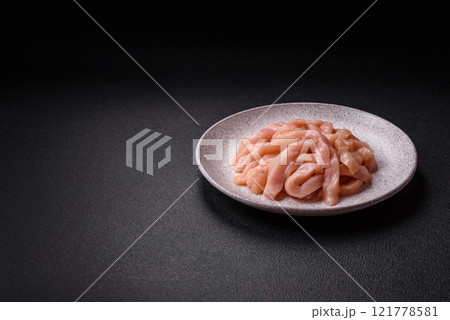 Raw chicken fillet cut into strips with spices and herbs 121778581