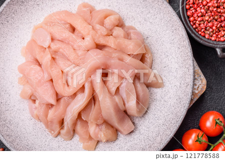 Raw chicken fillet cut into strips with spices and herbs Raw chicken fillet cut into strips with spices and herbs 121778588