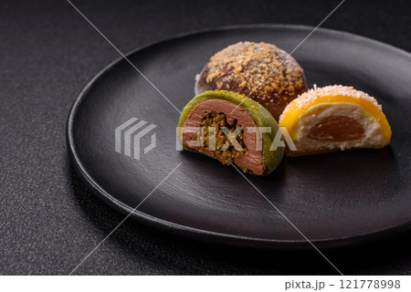 Delicious colorful asian mochi sweets with rice dough shell and fruit filling Delicious colorful asian mochi sweets with rice dough shell and fruit filling 121778998