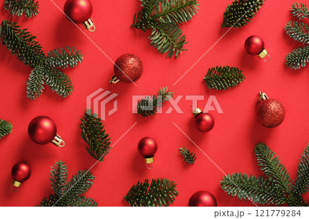 Christmas background with green pine sprigs and red Christmas baubles. Red background. Christmas background with green pine sprigs and red Christmas baubles. Red background. 121779284