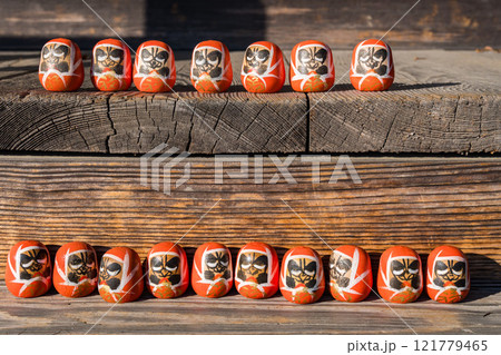 ベンチに座る小さなだるまたち 121779465