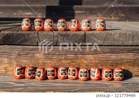 ベンチに座る小さなだるまたち 121779466