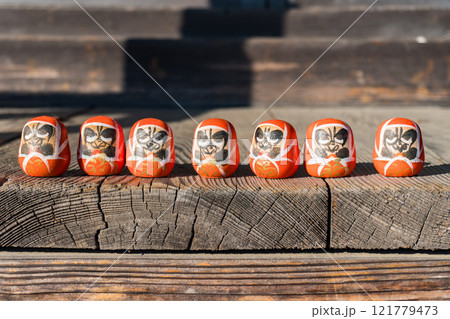 ベンチに座る小さなだるまたち 121779473