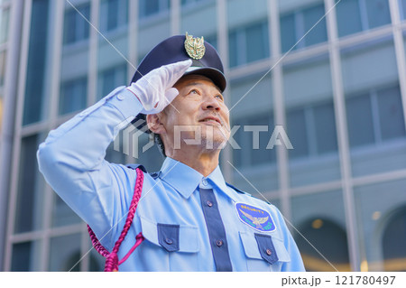 敬礼するミドルエイジの男性警備員　撮影協力：学校法人電波学園　東京電子専門学校 121780497