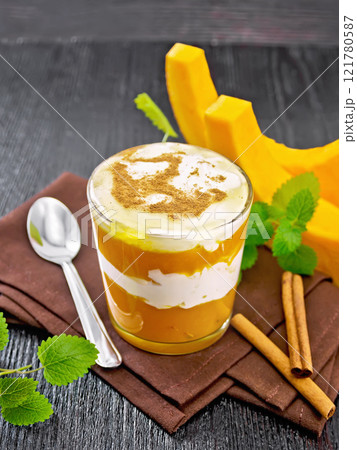 Dessert of pumpkin and yogurt in glass on board Dessert of pumpkin and yogurt in glass on board 121780587