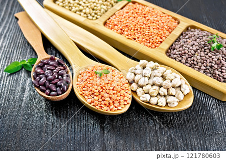 Lentils red with chickpeas and beans in spoons on dark board 121780603