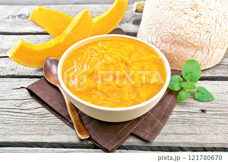 Pumpkin puree in bowl on old wooden board 121780670