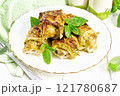 Rolls of zucchini with meat in plate on white board 121780687