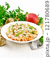 Salad of Jerusalem artichoke and apple in plate on table 121780689