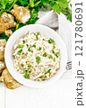 Salad of Jerusalem artichoke and eggs in plate on light board top 121780691