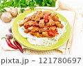 Stir-fry of chicken with peppers in plate on board 121780697
