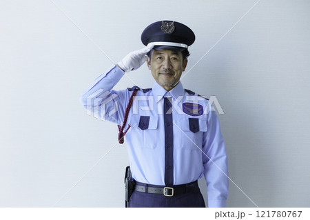 白背景の敬礼するミドルエイジの男性警備員　撮影協力：学校法人電波学園　東京電子専門学校 121780767