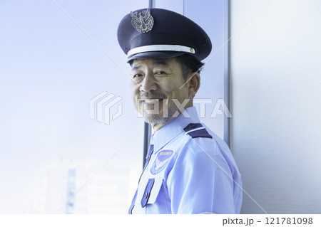 窓の外を見るミドルエイジの男性警備員　撮影協力：学校法人電波学園　東京電子専門学校 121781098