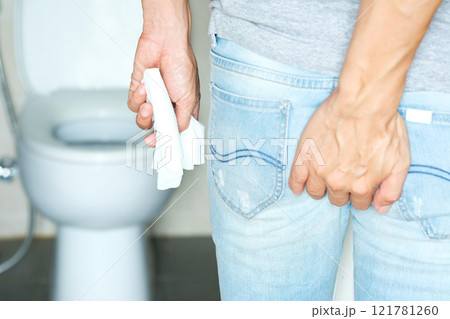 Man's hand, he holds a roll of toilet paper Going to the bathroom Toilet toilet background 121781260