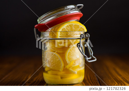 sliced lemons in sugar syrup in a glass jar, canned sliced lemons in sugar syrup in a glass jar, canned 121782326