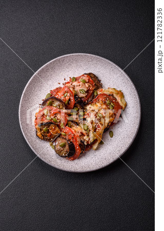 Rings of eggplant, tomato and zucchini with pieces of chicken and garlic 121782336