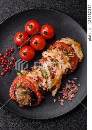 Rings of eggplant, tomato and zucchini with pieces of chicken and garlic 121782350