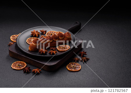 Sweet eclair with chocolate custard sprinkled with cocoa powder 121782567