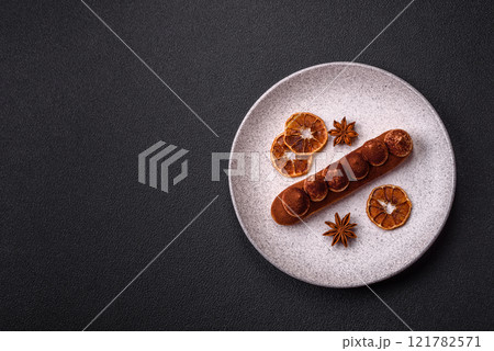 Sweet eclair with chocolate custard sprinkled with cocoa powder Sweet eclair with chocolate custard sprinkled with cocoa powder 121782571