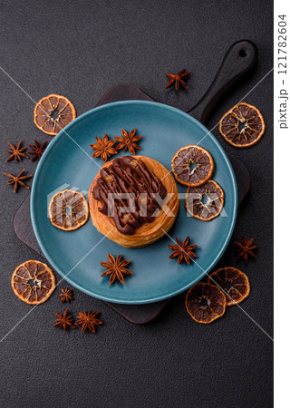 Sweet dessert danish covered with chocolate cream, with cream filling Sweet dessert danish covered with chocolate cream, with cream filling 121782604
