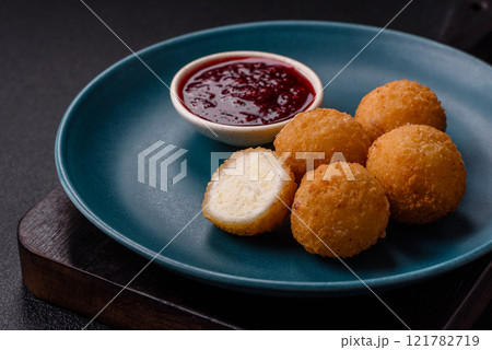 French fries balls with breaded brie or camembert cheese with sweet berry sauce French fries balls with breaded brie or camembert cheese with sweet berry sauce 121782719
