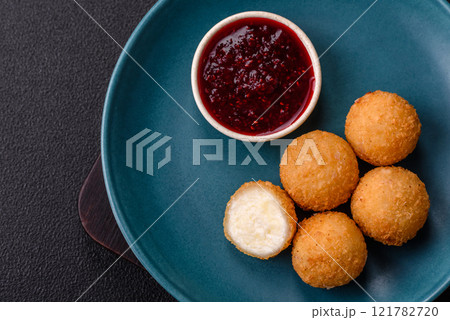 French fries balls with breaded brie or camembert cheese with sweet berry sauce French fries balls with breaded brie or camembert cheese with sweet berry sauce 121782720