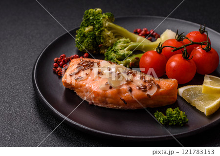 Grilled salmon with salt and spices, broccoli, tomatoes, rice 121783153