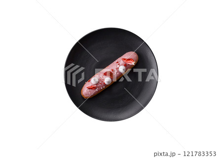Sweet eclair or profiterole with strawberry custard 121783353