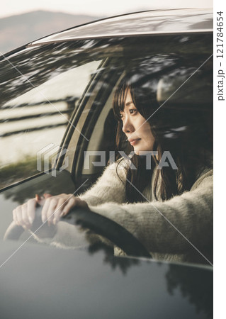 車の運転をするロングヘアの若い女性 121784654