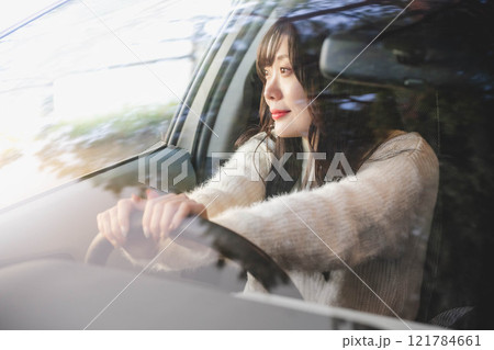 車の運転をするロングヘアの若い女性 121784661