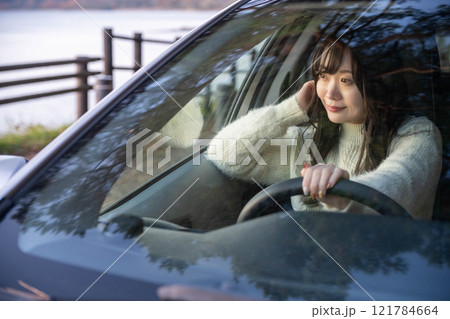 車の運転をするロングヘアの若い女性 121784664