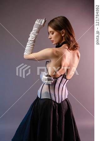 Woman in elegant corset and gloves showcases modern lingerie fashion design 121784862