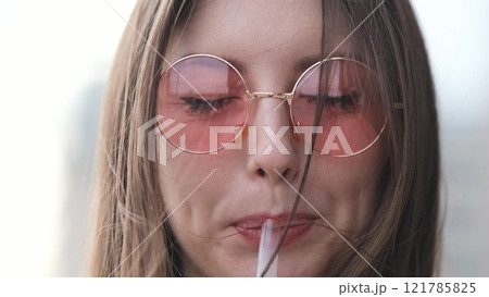 Pensive happy woman sipping a milkshake in the street 121785825