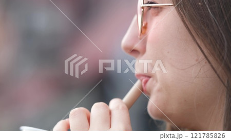 Pensive happy woman sipping a milkshake in the street 121785826